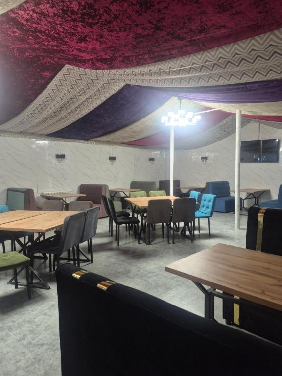 a dining room with wooden tables and chairs at Nur Guest House 17 in Saty