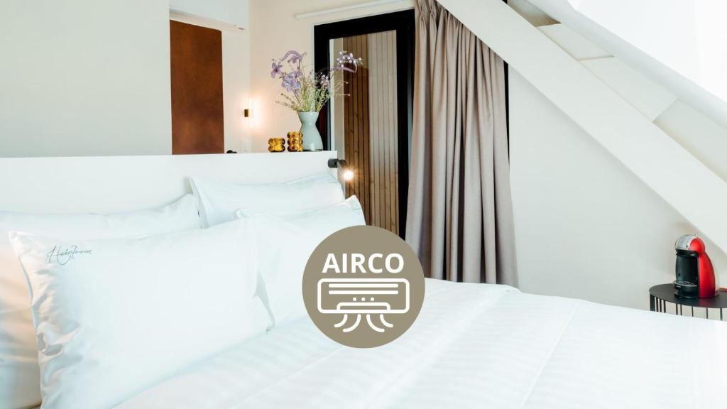a bedroom with a white bed with a sign on it at The Librarian by Domani Hotels in Ghent