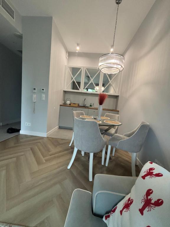 a dining room and kitchen with a table and chairs at Olsztyn Kapitańska 2 in Olsztyn