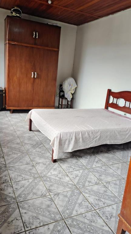 a bedroom with a bed and a wooden cabinet at downtown Teófilo Otoni in Teófilo Otoni