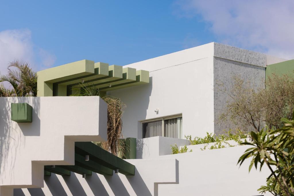 a white house with stairs and trees at Good Days Caesar in Ras Elhekma