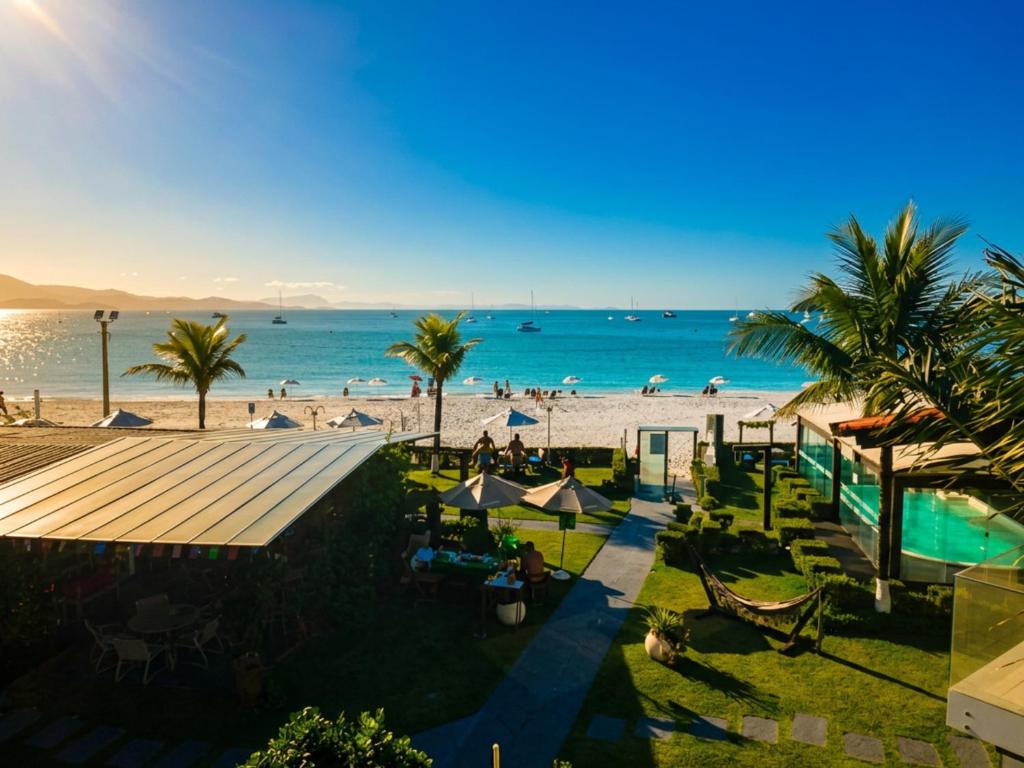 una vista dall'alto di una spiaggia con palme e l'oceano di Hotel Sete Ilhas a Florianópolis