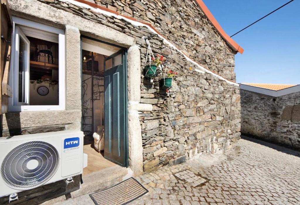 a stone house with a fan outside of a building at Romantic Room - Charming Place in Provesende