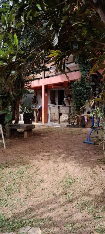a building with a pink roof with a bench in front at Recanto da Serra e camping in Itamonte