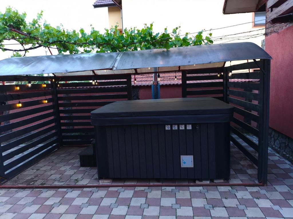 a black trash can sitting next to a fence at Casa Drăgan in Novaci-Străini