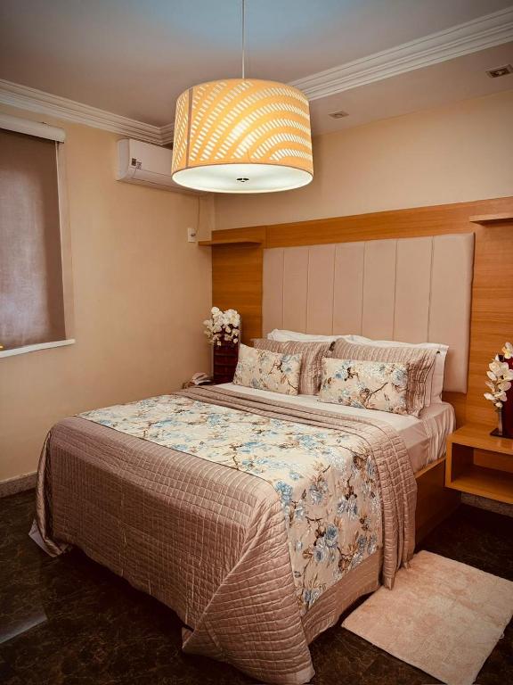 a bedroom with a large bed in a room at Hotel Cravo e Canela in Campos dos Goytacazes