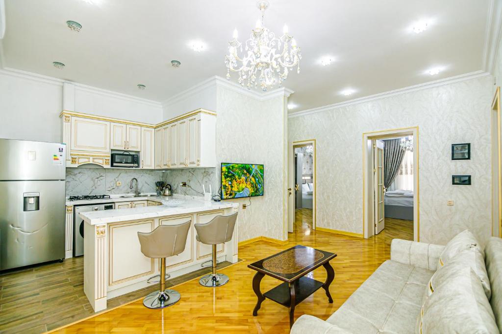 a kitchen and living room with a couch and a table at Kolorit Modern Apartment in Baku