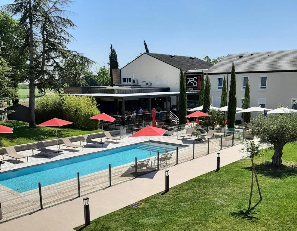 a pool with chairs and umbrellas in front of a hotel at Logis Hotel Relais Saint Jacques - Châteauroux in Déols