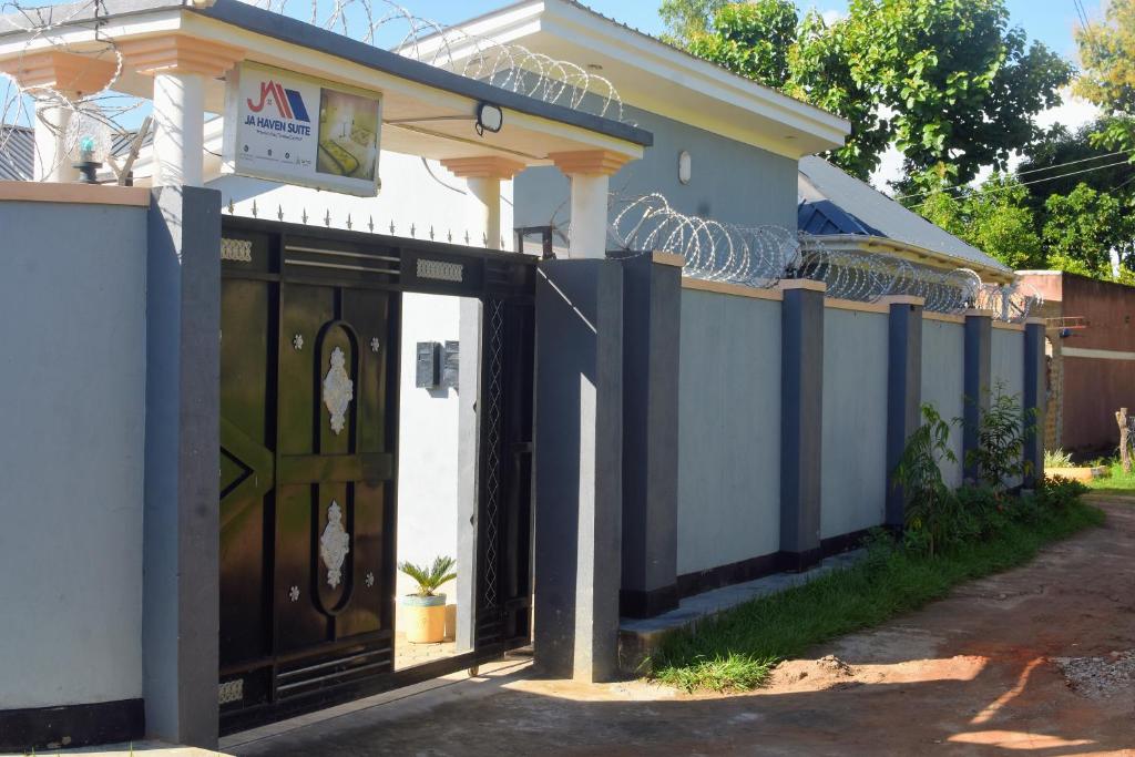 a house with a gate and a fence at JA Haven Suite in Lira