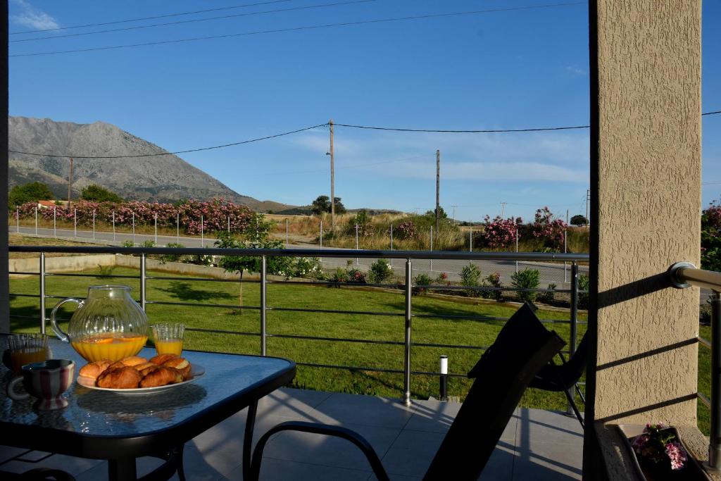 a table with a bowl of bread and glasses of orange juice at Saonia Apartment in Samothraki