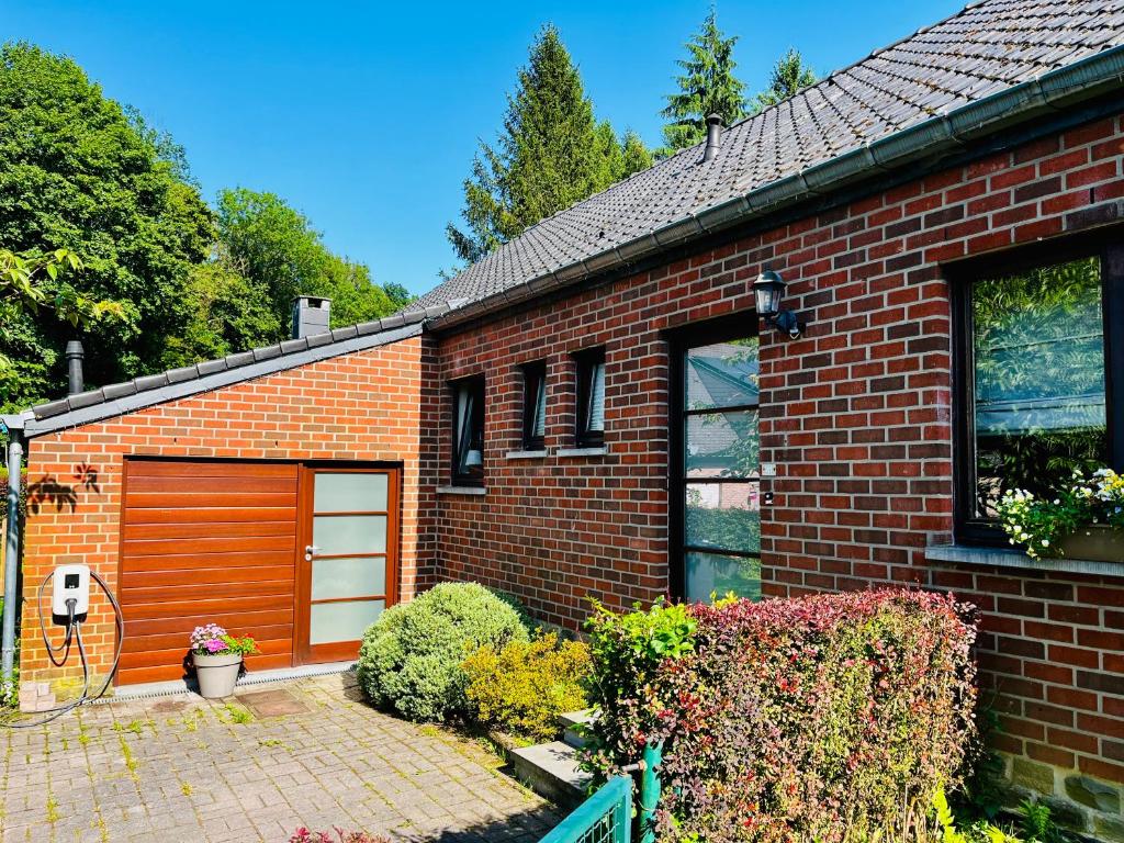 a red brick house with a brown garage at Chez Sophie in Spa