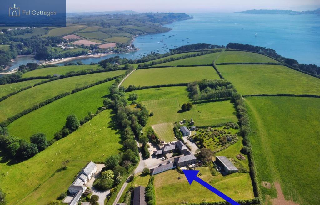 an aerial view of a house in a field with a blue arrow at Karadow in Saint Just in Roseland