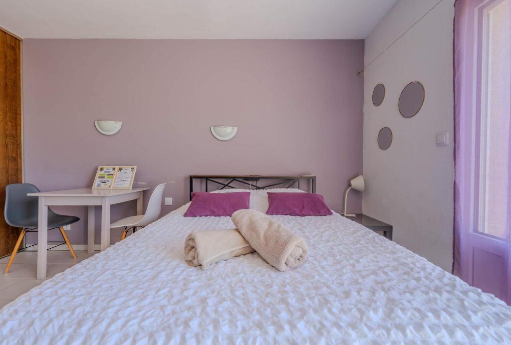 a bedroom with a bed with two towels on it at Appartement Lilas - Résidence Kiwi in Aytré