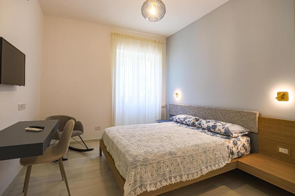 a bedroom with a bed and a desk and a window at Donna Maria Apartments - Amami Collection in Amalfi