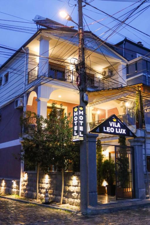 a building with a lit up sign in front of it at Vila Leo Lux in Korçë