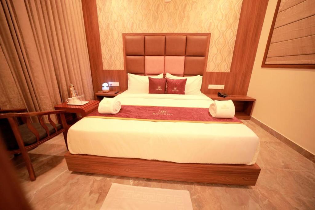 a bedroom with a large bed with a wooden headboard at LUMARISE Hotel in Sultan Bathery