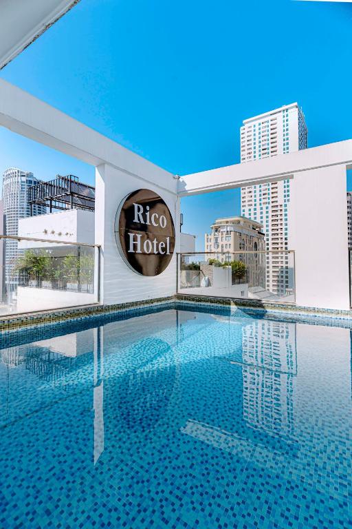 a large swimming pool in a building with a hotel sign at Rico hotel Nha Trang in Nha Trang