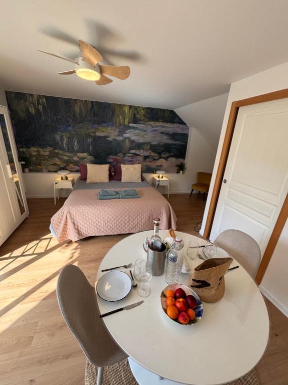 a living room with a table and a bed at Maison Floréal Giverny in Giverny