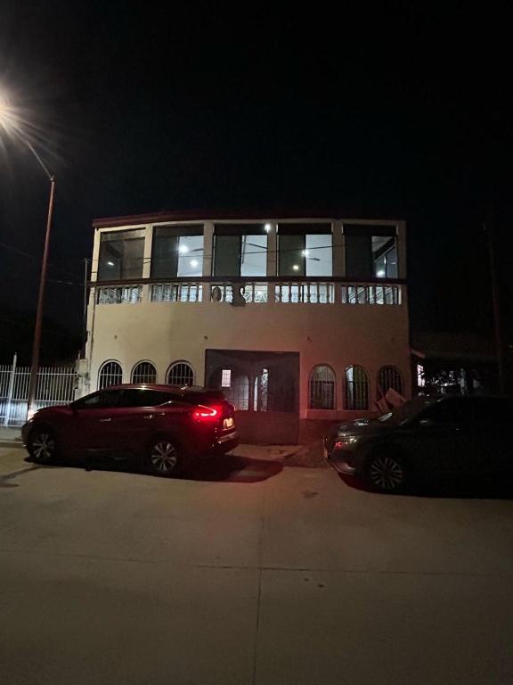 a red car parked in front of a building at night at Excente alojamiento in Zaragoza