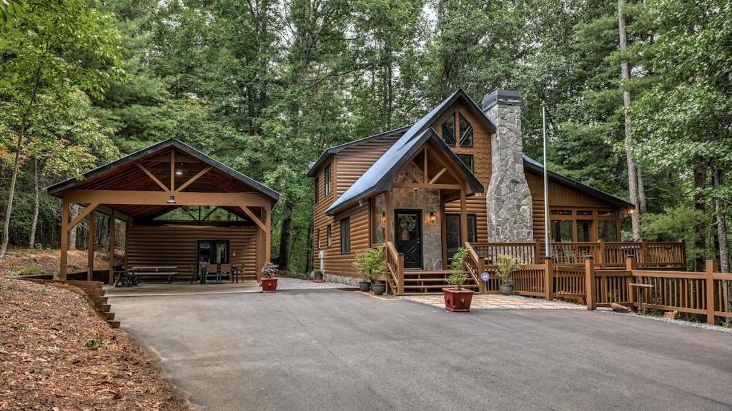a log cabin in the woods with a driveway at Among the Trees in Epworth