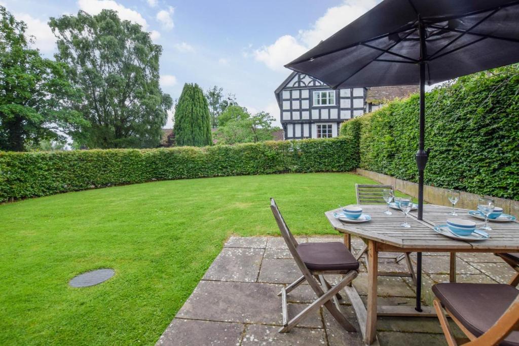 a patio with a table and chairs and an umbrella at 2 Bed in Ludlow oc-59293 in Lane to Richards Castle