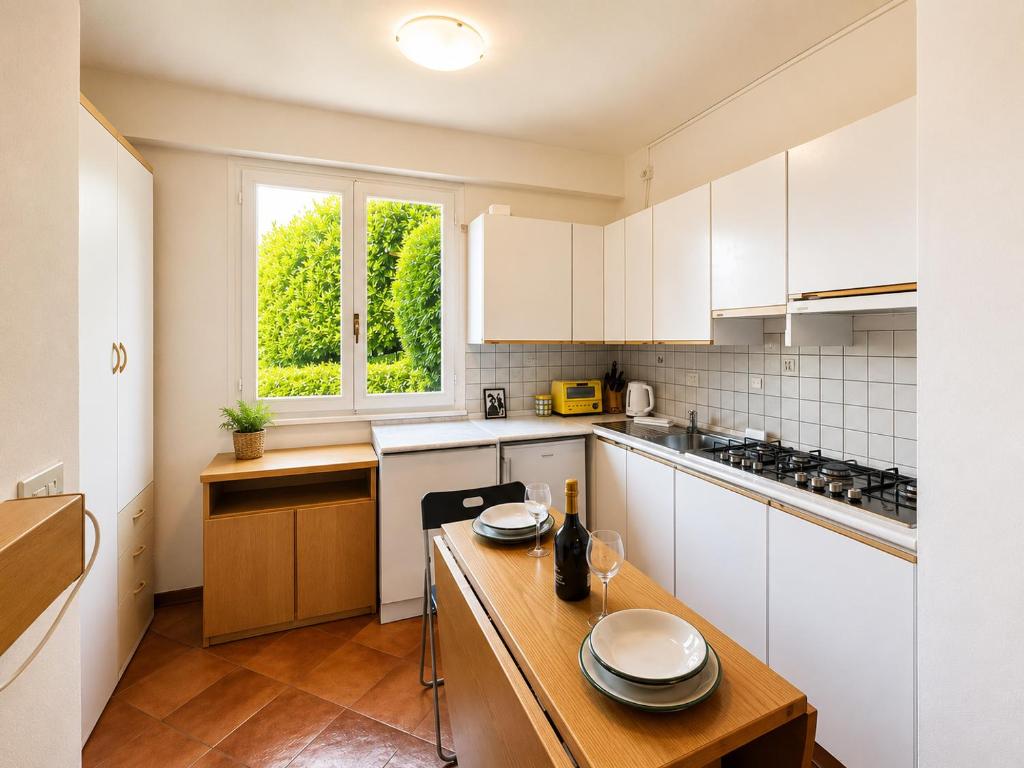 a kitchen with white cabinets and a wooden table at Casa Leima - Larihome A83 in Gera Lario