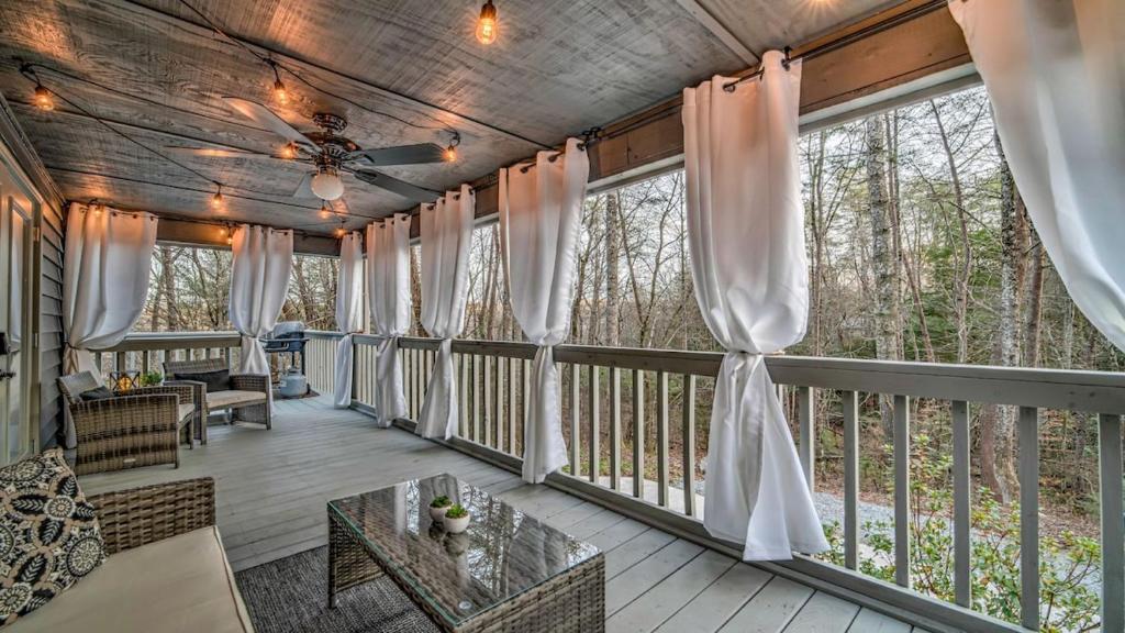 a screened in porch with curtains and a table at Love Affair in Epworth