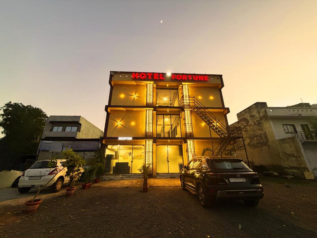 a building with a car parked in front of it at Hotel Fortune, Althan in Surat