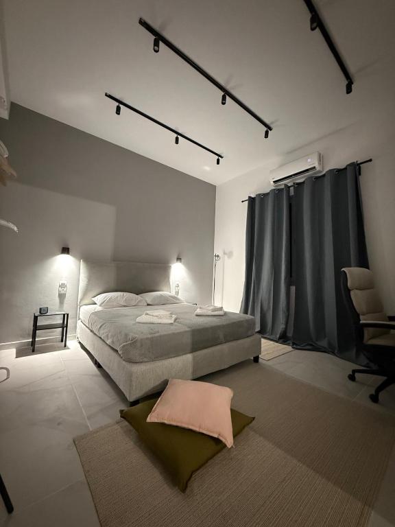 a white bedroom with a bed and a chair at Slow Living Home in Kilada