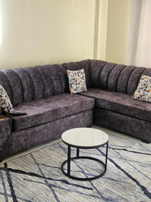 a couch with a coffee table in a living room at Sky-Host, Dulham suite in Homa Bay