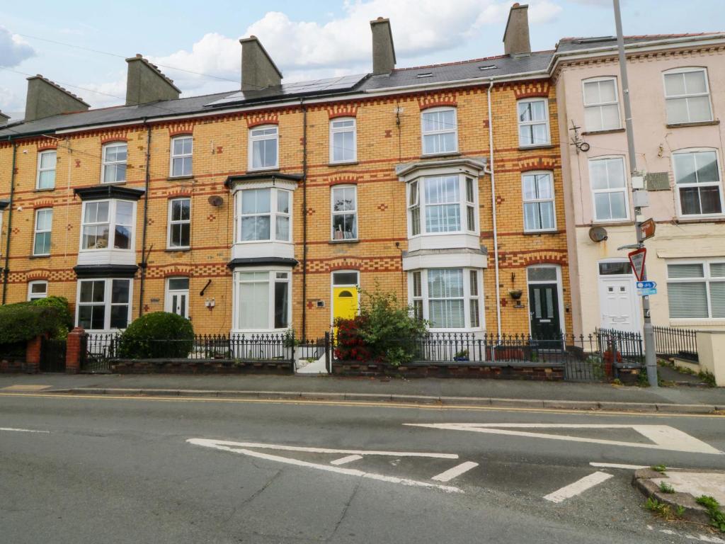 a large brick building on the corner of a street at Jack's House in Tywyn