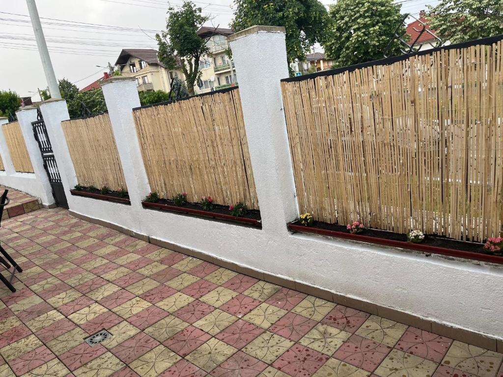 a wooden fence with flowers on it next to a sidewalk at Casa Clara in Techirghiol