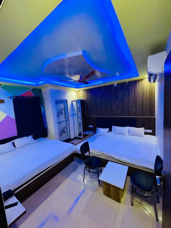 a room with two beds and a table and chairs at Hotel sagar inn in Ajmer
