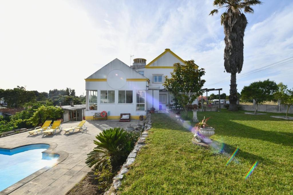 a house with a swimming pool and a backyard at Casa do Sol Wellness Home in Óbidos