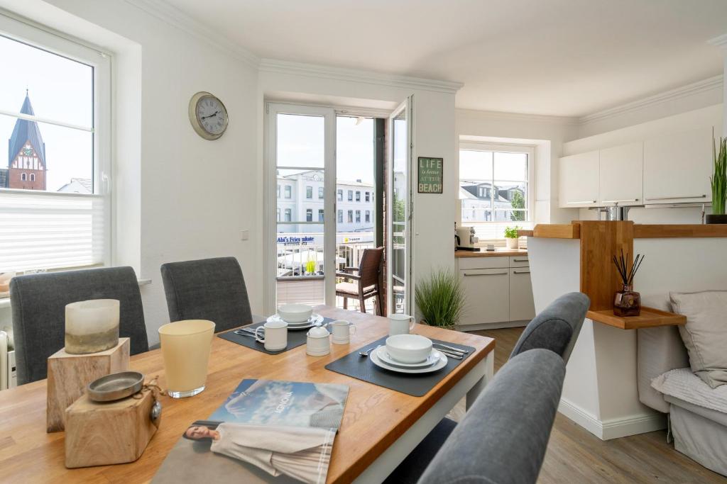a living room with a table and chairs and a kitchen at Syltliebe in Westerland
