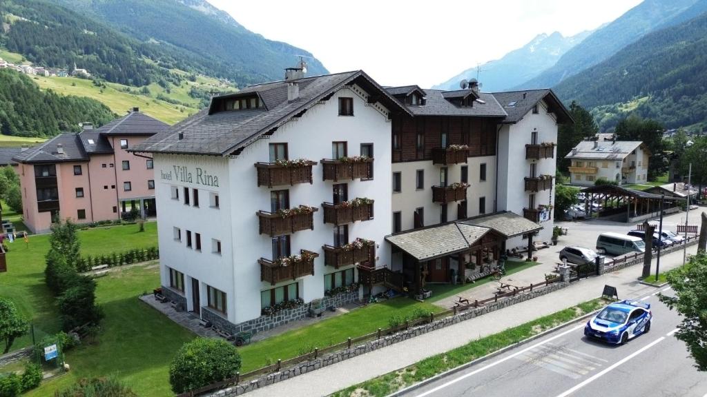 a large white building on the side of a street at Hotel Villa Rina in Bormio