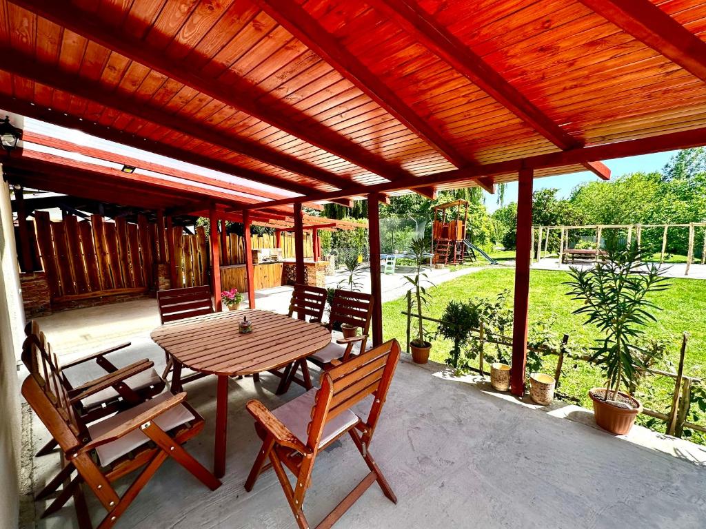 a wooden table and chairs on a patio at Liliput Apartman in Sarkad