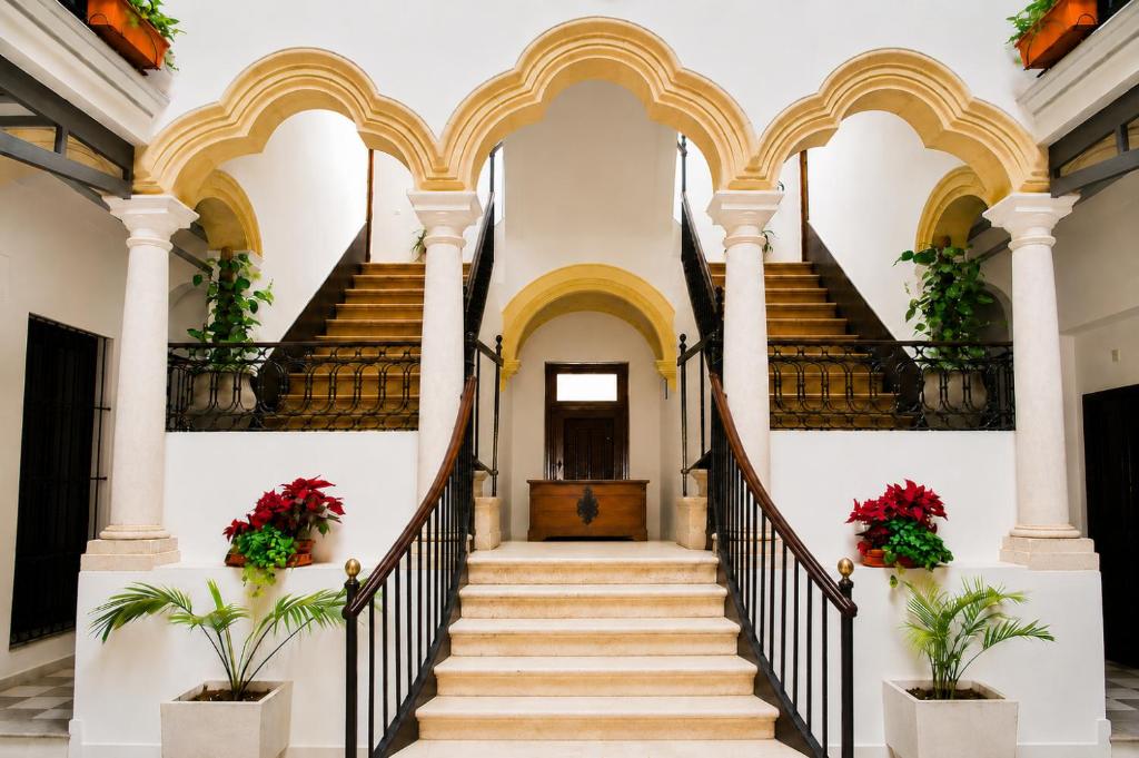 a staircase in a building with red flowers at Apartamentos Larga 70 in El Puerto de Santa María