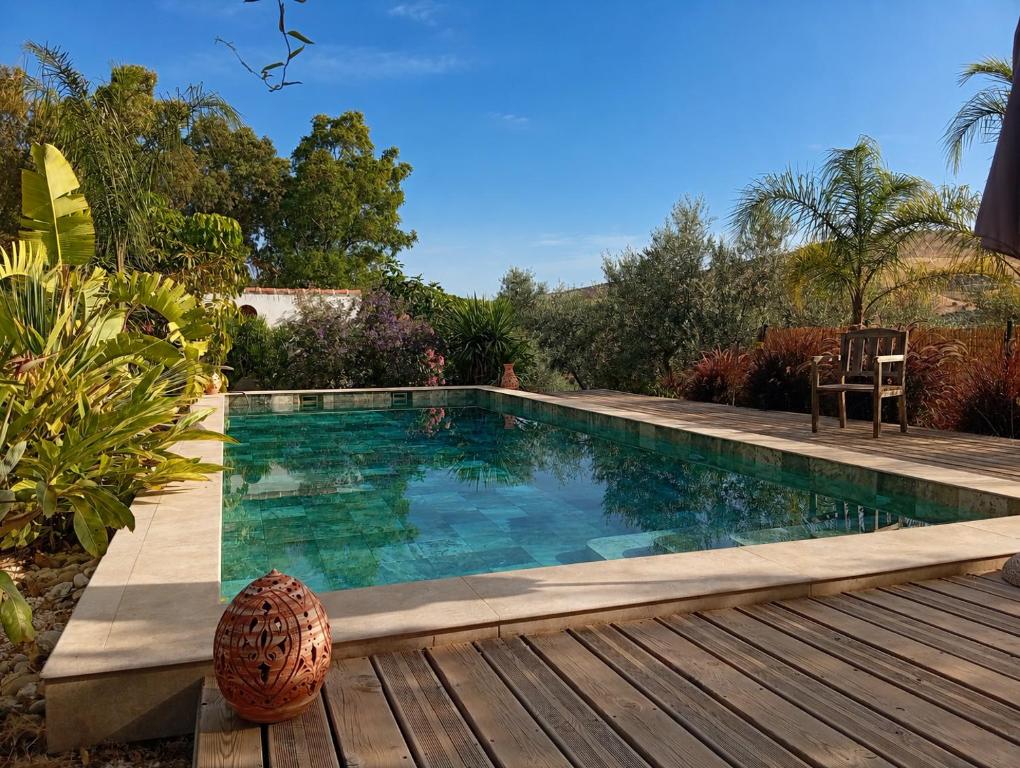 a swimming pool in a yard with a wooden deck at Finca Altozano - Private pool in Valle de Abdalagís