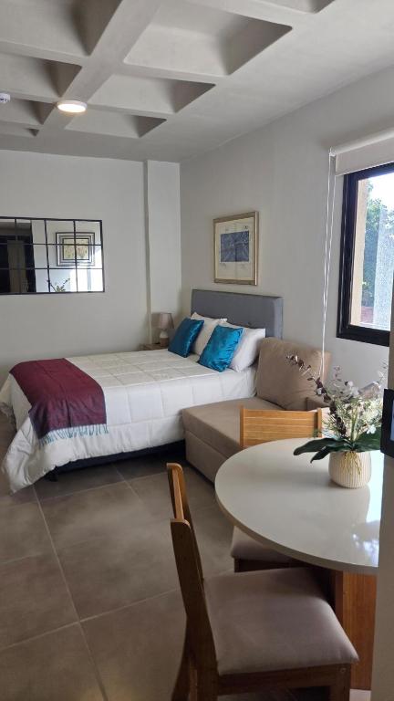 a bedroom with a bed and a table and a couch at #5 Monoambiente, Pool, Grill, Gym, Sauna in Nu Guazu