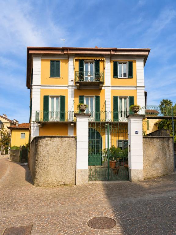 a yellow building with a gate in front of it at Ca del Lac, few steps from Lake Maggiore in Porto Valtravaglia