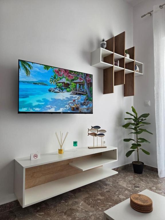 a living room with a tv on a white wall at Loutraki Cozy Loft in Loutraki