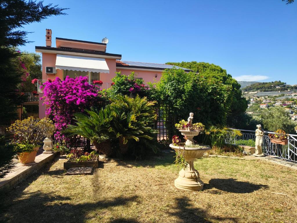a garden with a fountain in front of a house at Sunset Garden Sanremo in Sanremo
