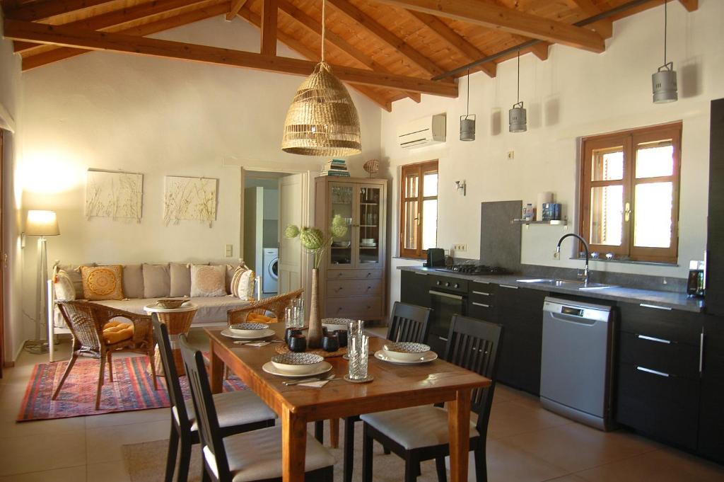 a kitchen and living room with a table and a dining room at The Art House in Kotrónion