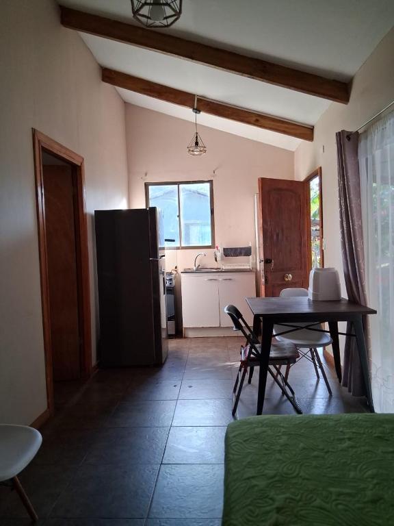 a kitchen with a table and a refrigerator in a room at Kauaraki Henua Iti in Hanga Roa