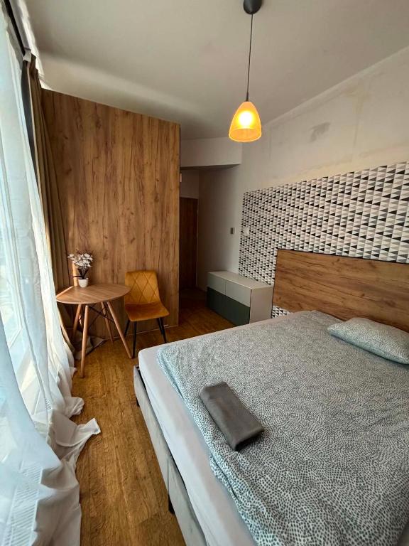 a bedroom with a large bed and a table at Pokoje w Centrum - Parking - Rowery in Sopot