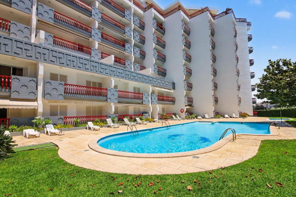 a large building with a swimming pool in front of it at T2 Tivoli in Vilamoura