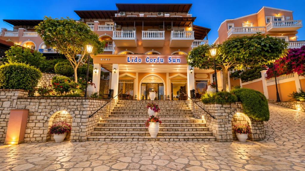 a hotel with stairs in front of a building at Lido Corfu Sun Hotel 4 Stars All-inclusive in Benitses