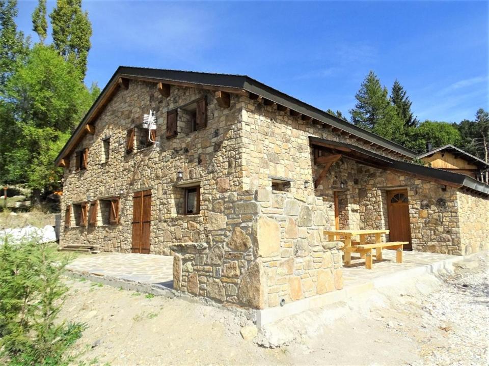 a stone building with a picnic table in front of it at Can PUGAT in Bolquere Pyrenees 2000
