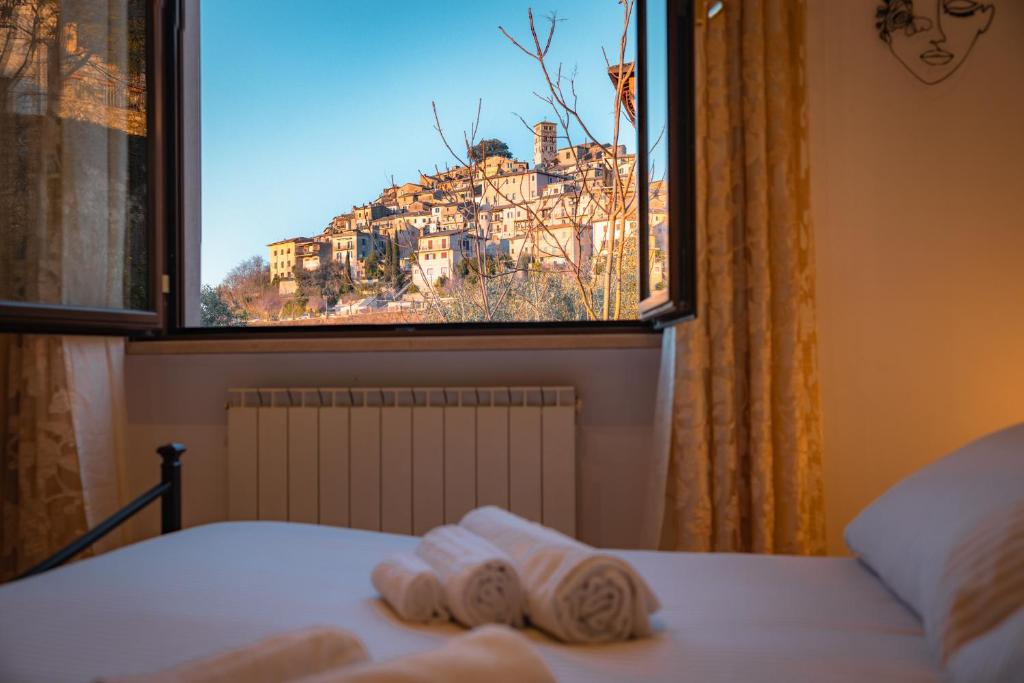 ein Schlafzimmer mit Fenster und Handtüchern auf dem Bett in der Unterkunft Casa Stefano in Casperia